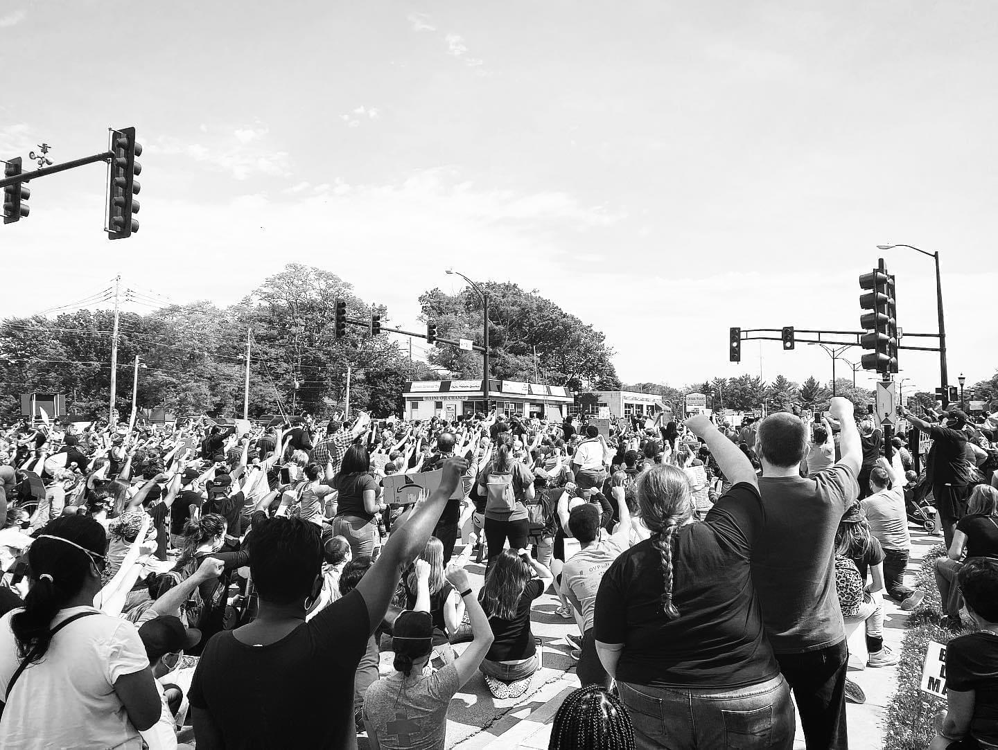 Protestors kneel at the intersection of Vine and Main streets in Urbana to show solidarity with George Floyd